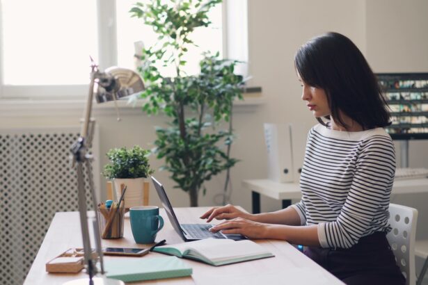 a woman sitting at a desk using a laptop computer